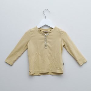Pompdeluxin pitkähihainen paita koossa 80. Paita on väriltään pastellin keltainen ja resoreissa on kimalletta.